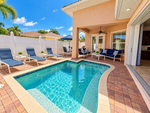 A swimming pool with lounge chairs and a patio area. -  Best Value In Naples Grand luxury 3 Bdrm Pool Spa Walk Bike To Gulf Spotless (Naples)