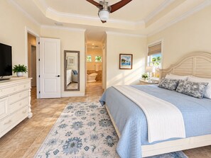 A bedroom with a bed, a dresser, a television, and a bathroom visible through an open door. -  Best Value In Naples Grand luxury 3 Bdrm Pool Spa Walk Bike To Gulf Spotless (Naples)