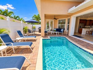 A swimming pool with lounge chairs and a patio area. -  Best Value In Naples Grand luxury 3 Bdrm Pool Spa Walk Bike To Gulf Spotless (Naples)