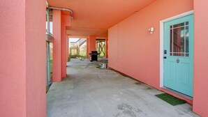 A corridor with a teal door, pink walls, and a concrete floor. - 🌅Oceanfront  🏖️Steps to sand 🐶Dog Friendly⚡️EV charger (North Topsail Beach)