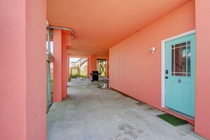 A corridor with a teal door, pink walls, and a concrete floor. - 🌅Oceanfront  🏖️Steps to sand 🐶Dog Friendly⚡️EV charger (North Topsail Beach)