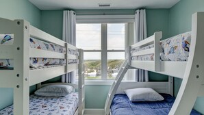 A bunk bed room with a window view, a ceiling vent, and a light switch. - 🌅Oceanfront  🏖️Steps to sand 🐶Dog Friendly⚡️EV charger (North Topsail Beach)