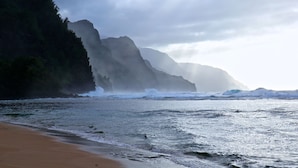 Un paysage côtier avec une falaise rocheuse et des vagues qui déferlent sur le rivage.