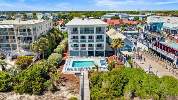 Ein mehrstöckiges Hotel mit Schwimmbad, umgeben von Grünflächen und anderen Gebäuden.