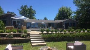 Un espace patio aménagé avec des sièges extérieurs, un foyer et une allée couverte menant à un bâtiment.