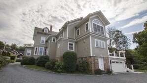 A two-story house with a stone foundation, a driveway, and a garage.