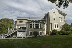 A two-story house with a front porch, a small front yard, and a staircase leading to the upper level.