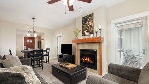 A living room with a fireplace, a dining area, and a TV.