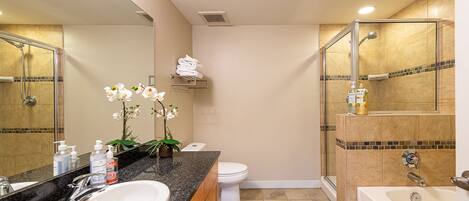 A modern bathroom with a sink, toilet, shower, and bathtub.