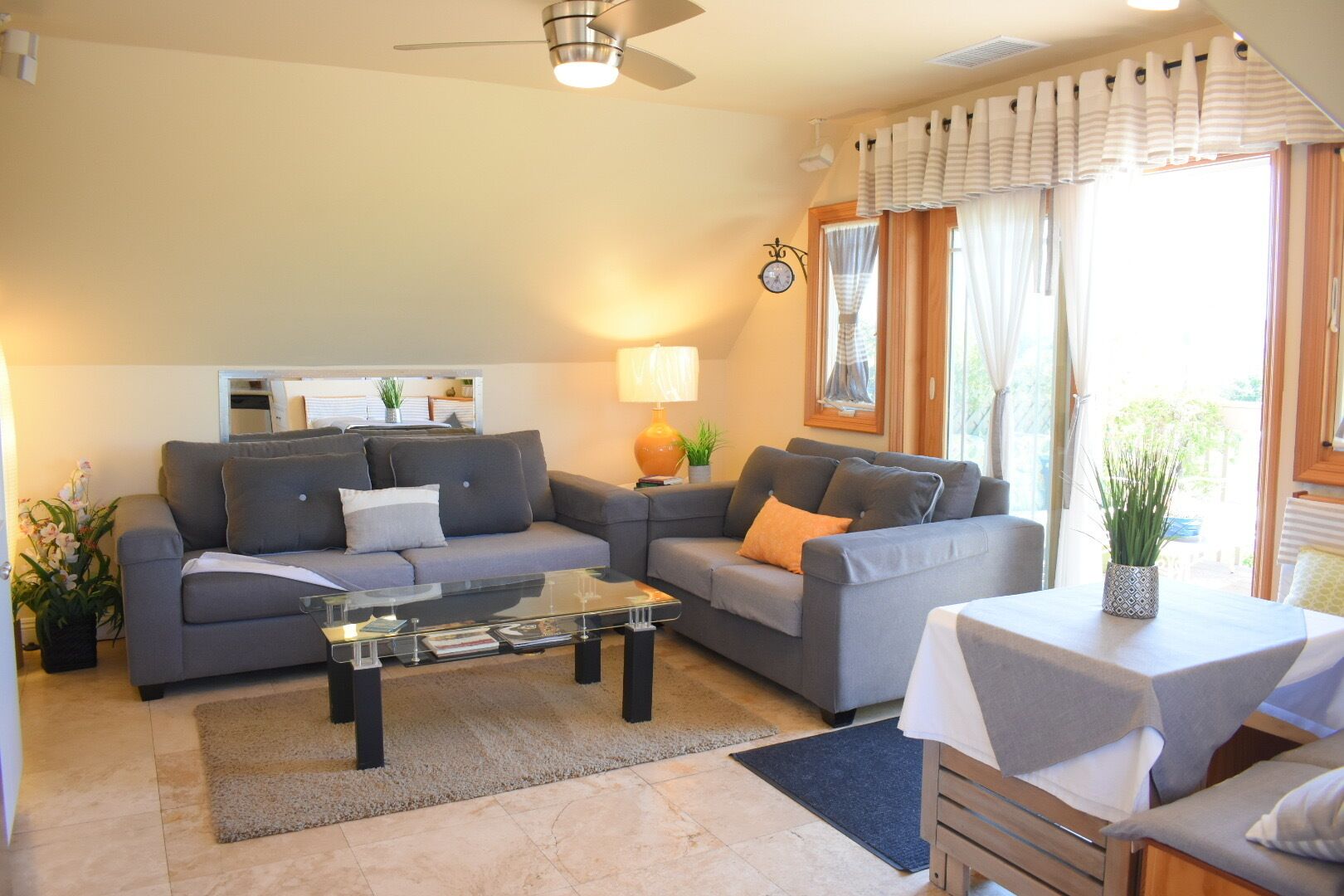 A modern living room with a sofa set, a coffee table, and a small table with a plant.