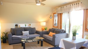 A modern living room with a sofa set, a coffee table, and a small table with a plant. - San Diego Country Barndominium, Mountain Views, Spa, Deck, & More. (Valley Center)