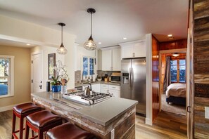 A modern kitchen with a central island, stainless steel appliances, and pendant lighting.