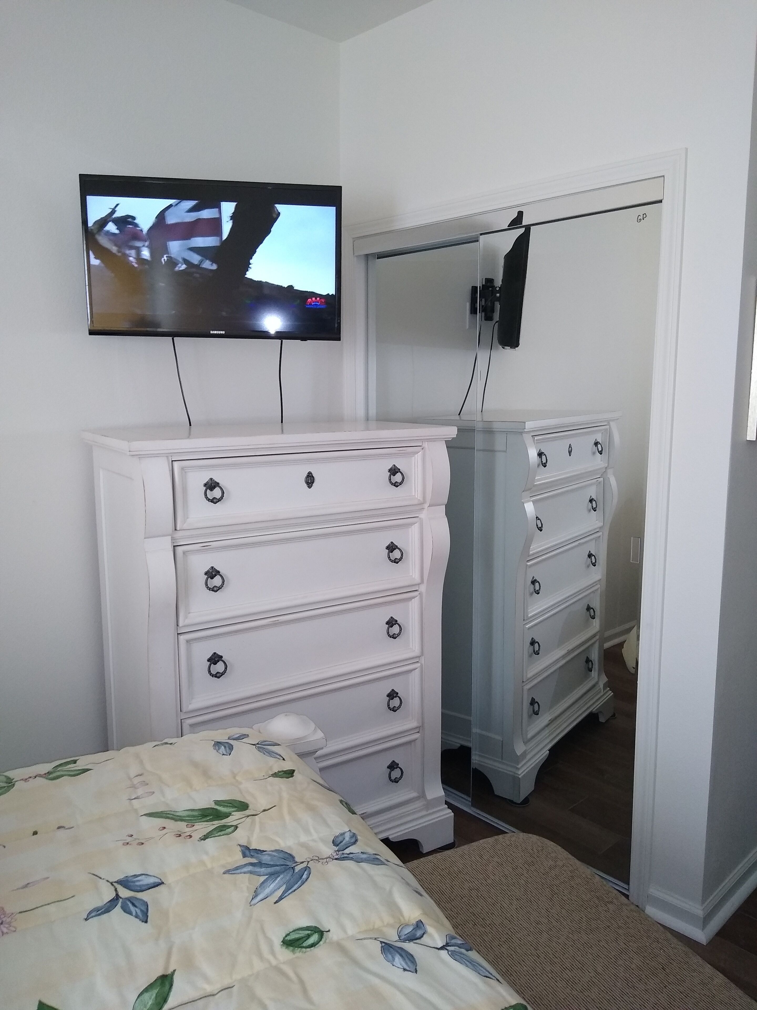 Makuuhuoneessa on sänky, lipasto ja seinälle asennettu televisio.