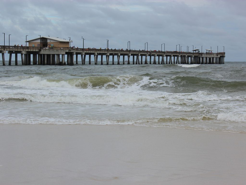 Une jetée qui s’avance dans la mer, avec un bâtiment à son extrémité.
