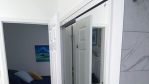Ein Schlafzimmer mit Bett, Nachttisch, Kommode und Kleiderschrank.