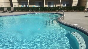 Ein klarer Pool mit einer Metallleiter und einer Fliesenleiste.