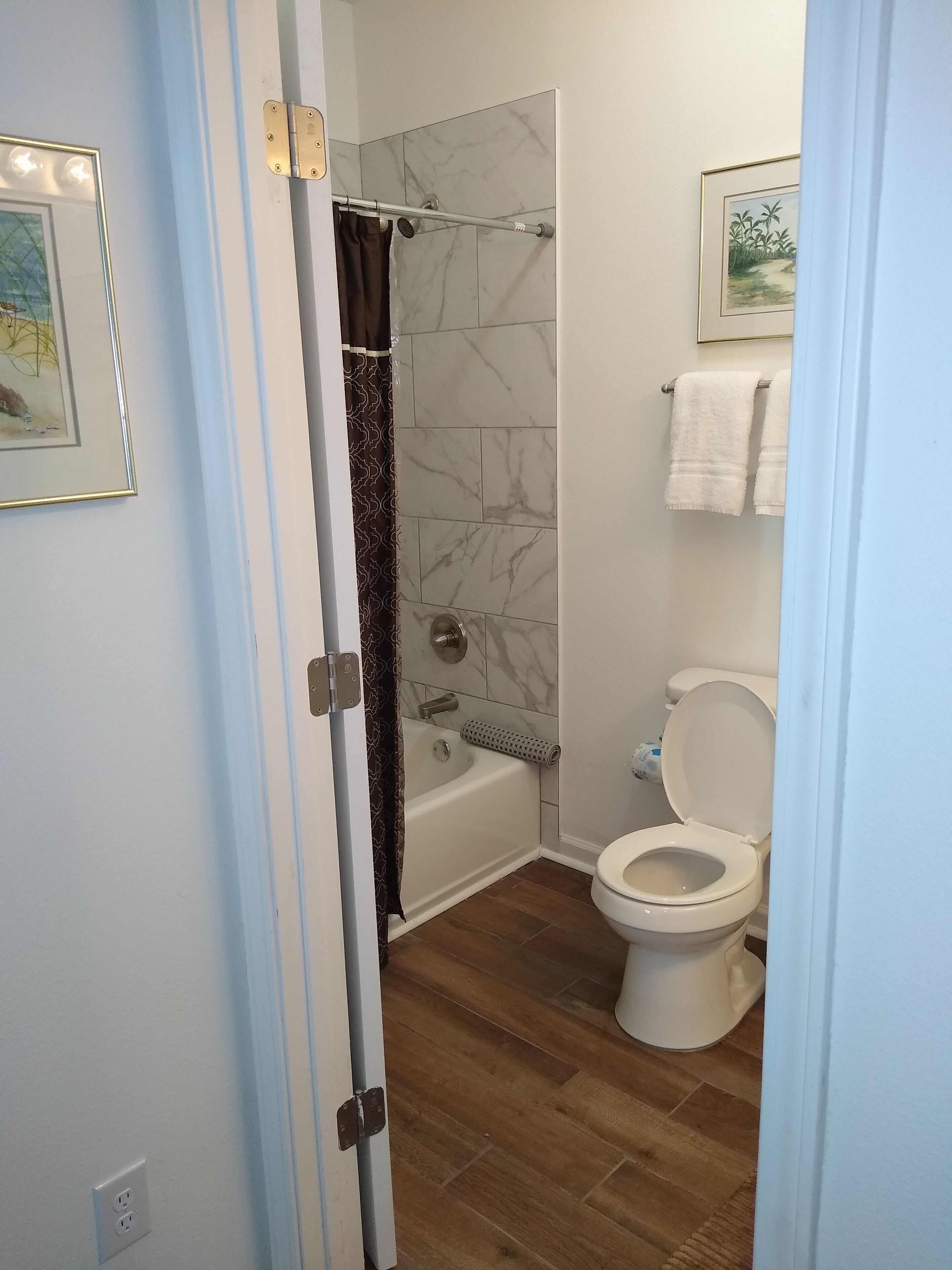 A bathroom with a bathtub, toilet, and shower curtain.