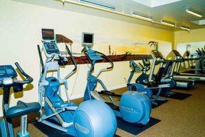 A gym with various exercise machines, including treadmills and elliptical trainers, arranged in rows. - STRIKING OCEAN VIEW STUDIO D210 FACING OCEANSIDE PIER (Oceanside)
