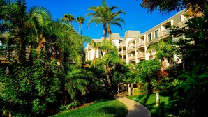 Un resort con edificios de varios pisos, abundante vegetación y un camino bien cuidado.