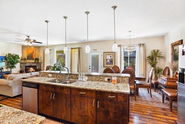 Relax in this inviting living area with a kitchen island, dining space, and cozy fireplace.