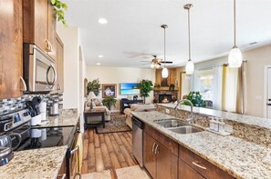 Enjoy cooking in the well-equipped kitchen with a stove, microwave, and dishwasher, and relax in the adjacent living area with a fireplace and comfortable seating.