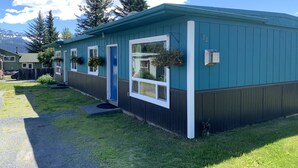 A single-story building with a blue exterior, a front door, and a small porch area. - 1 Block From The Beach! (Seward)