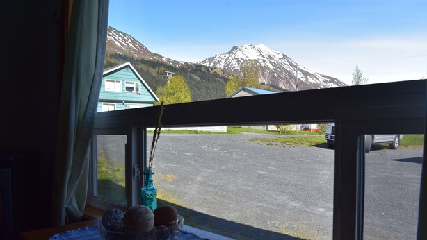 A room with a window overlooking a parking area and a mountain. - 1 Block From The Beach! (Seward)