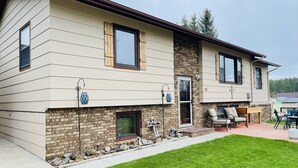 A two-story house with a brick facade, a front porch with a table and chairs, and a well-maintained lawn. - Downtown Custer &  neighbor to Rock Crest Lodge (Custer)
