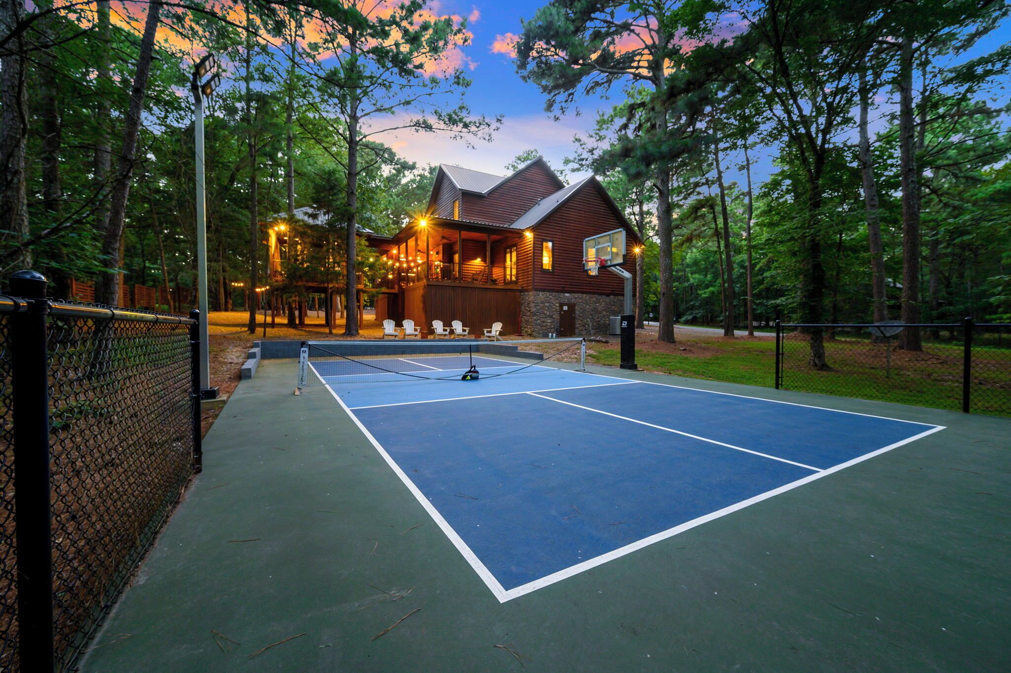 An outdoor tennis court with a wooden building in the background.