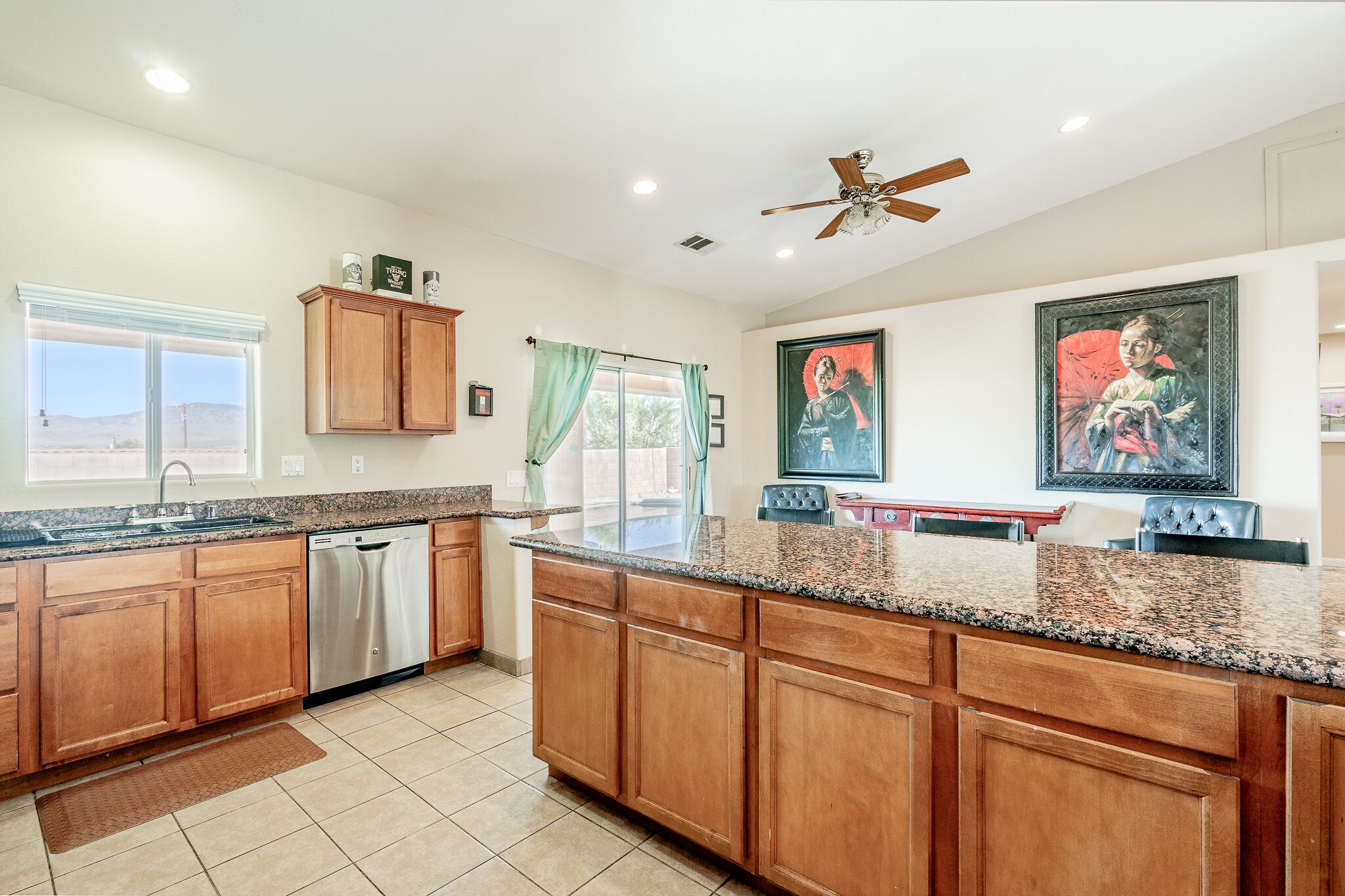 A spacious kitchen with wooden cabinets, granite countertops, and a dishwasher.