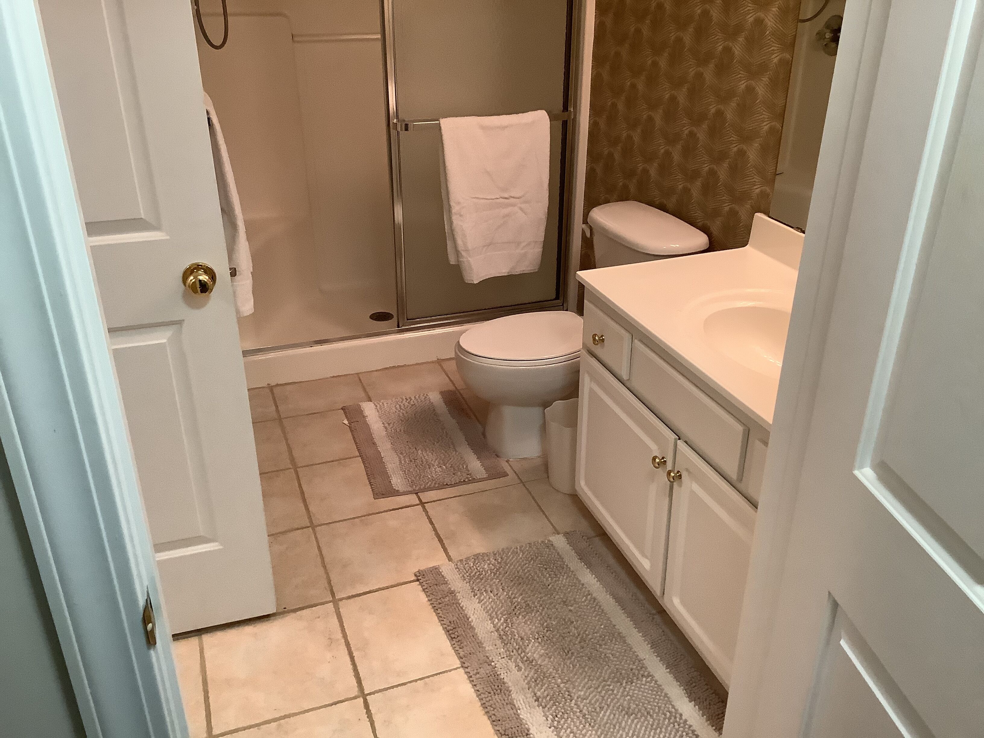 A bathroom with a shower, toilet, and sink.