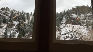 A room with two windows overlooking a snowy mountain landscape. - Missouri Riverfront Bungalow Near Craig MT. (Cascade)
