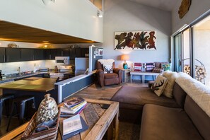 Relax in this stylish space with a comfortable sofa, coffee table, and reading nook, featuring a microwave, refrigerator, and large windows.