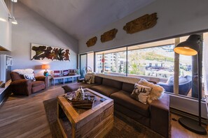 Relax in this stylish living room with a sofa set, coffee table, and wall art, offering a view of the surrounding area.