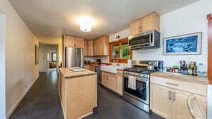 Une cuisine moderne avec des meubles en bois, des appareils en acier inoxydable et un îlot central.