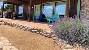 Un bâtiment de style rustique doté d’un patio couvert, de murs en pierre et d’un espace extérieur aménagé pour s’asseoir.