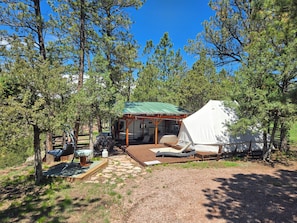 A rustic cabin with a green roof, a covered porch, and a white tent. - 29ft Alpha Wolf RV PLUS Sibley double bell tent COMBO! @EvansCliff, Hot Tub! (hot springs)