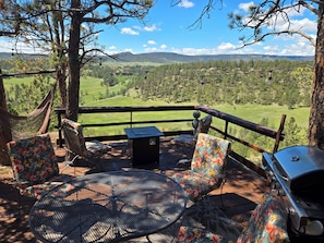 A deck with outdoor furniture, a grill, and a scenic view of a valley. - 29ft Alpha Wolf RV PLUS Sibley double bell tent COMBO! @EvansCliff, Hot Tub! (hot springs)