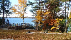 A lakeside park with a wooden deck, benches, and a statue.