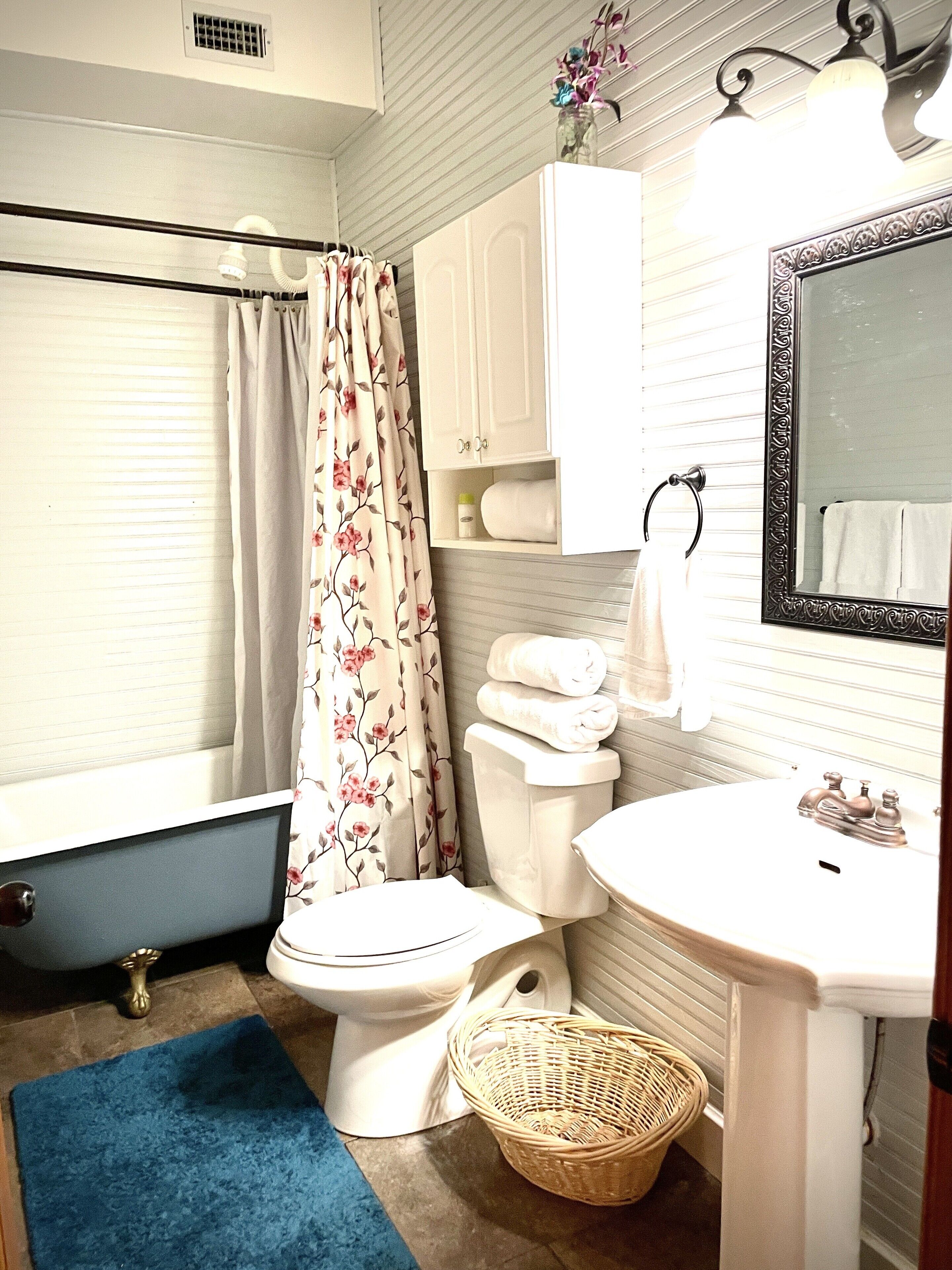 A bathroom with a toilet, sink, and a mirror.