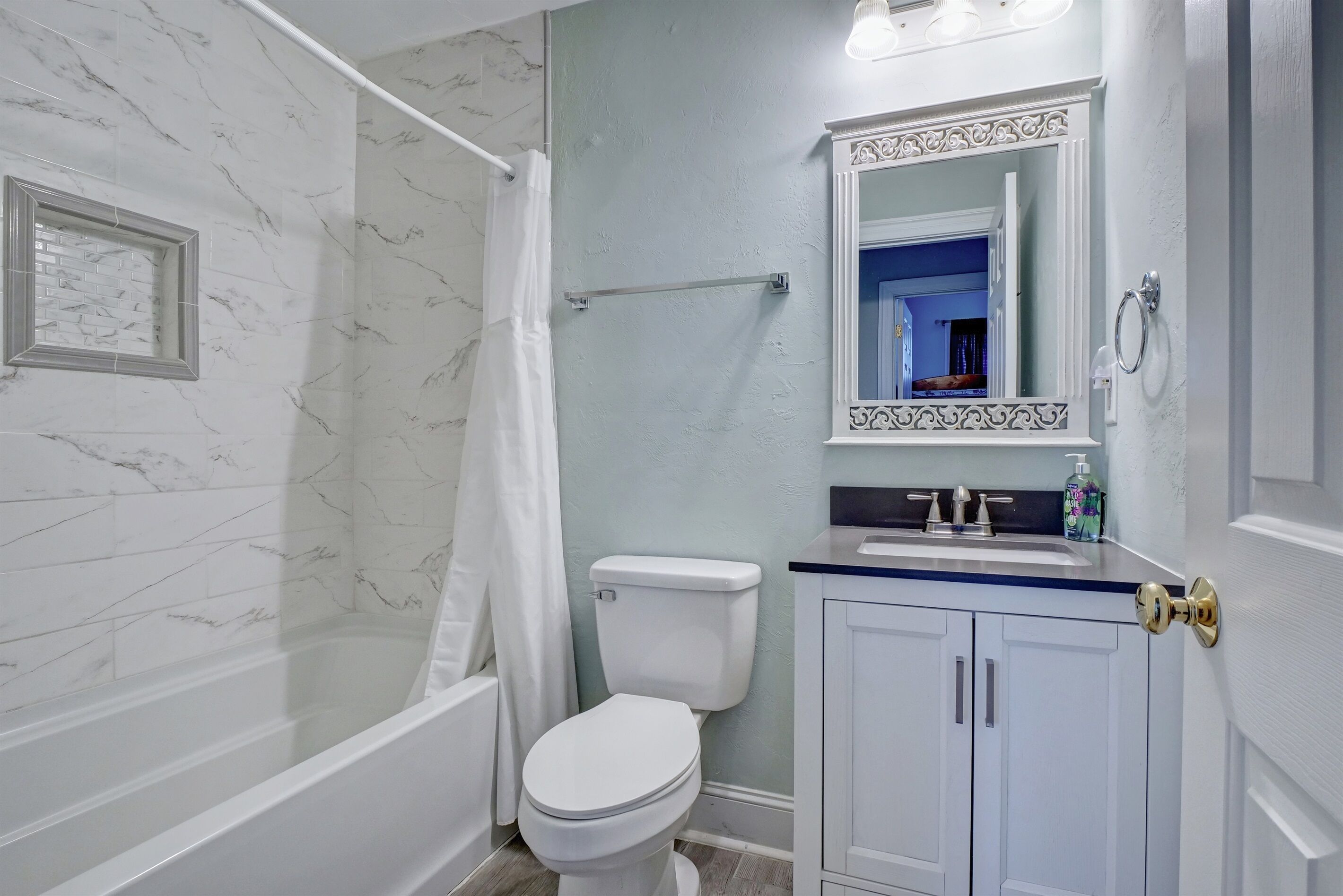 A bathroom with a shower, toilet, and sink.