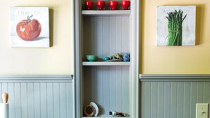 A kitchen with a built-in shelf unit containing red cups and a book titled "Tomato". - Historic 1870’s Spacious Home-2 Blocks From Belfast Village and the Bay (Belfast)