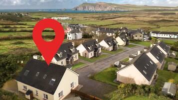Una zona residencial con casas, una carretera y un paisaje costero al fondo.