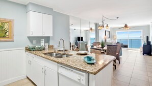 A modern kitchen with granite countertops, white cabinetry, and a large island. - NEWLY RENOVATED/DIRECT FRONT/2 BEDROOM CONDO/INDOOR-OUTDOOR POOL/NEAR ATTRACTION (Orange Beach)