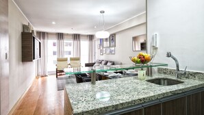 A modern kitchen with granite countertops, a glass-top dining table, and a built-in sink. - Luxury 2BDR in Miraflores - UP1, A/C, Soundproof windows, Pool, BBQ (Lima)
