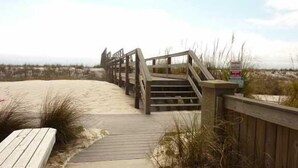 A wooden boardwalk leading to a beach area with a wooden staircase and a sign. - Paradise On The Beach With Crystal Clear Water & Gulf Front Complex--2 BR Suites (Navarre)