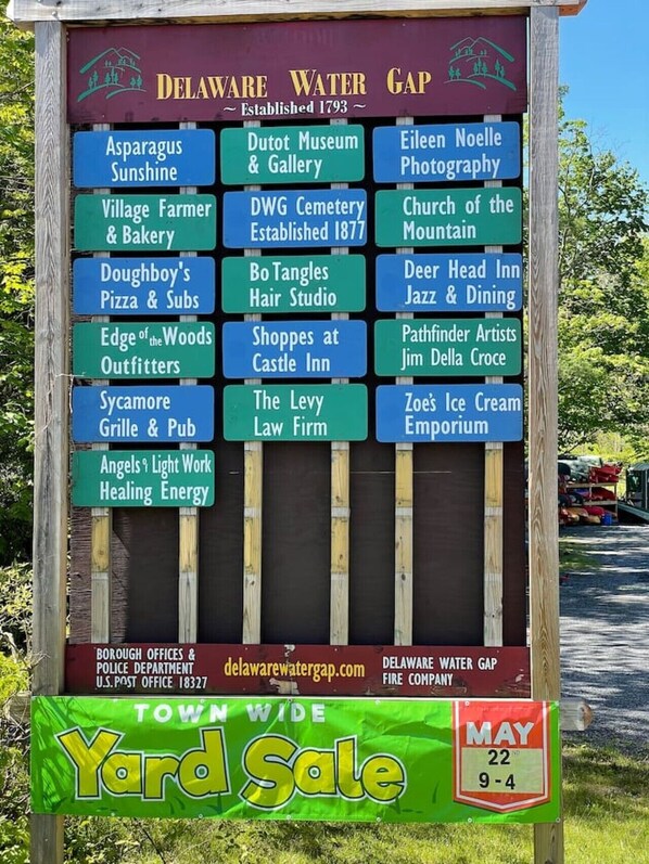 Un panneau indiquant divers commerces et attractions locales de Delaware Water Gap, notamment Asparagus Sunshine, le musée et la galerie Dwort, et le studio de photographie d’Eileen Noelle.