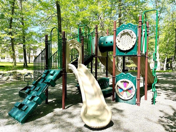 A playground with slides, climbing structures, and a large spiral slide.