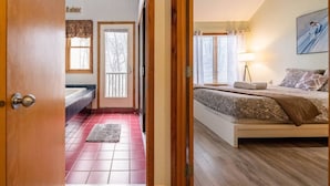 A bedroom with a bed, a nightstand, a lamp, and a painting on the wall.