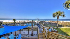 A beachside deck with blue chairs and a wooden walkway leading to the beach. - Beautiful Beachfront Studio with Beach Chairs for 2 (Panama City Beach)
